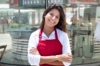 Foto: Junge Kellnerin vor dem Restaurant